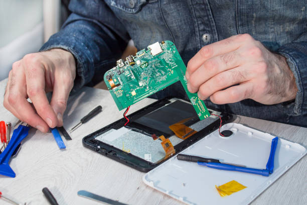 istock Electronic service employee holds the tablet's integrated circuit in his hands. 962225544