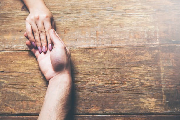 istock Closeup on two young lovers holding hands at a table 962226932