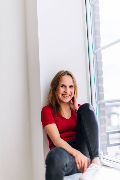 istock A friendly and smiling girl sitting by the window 962233628