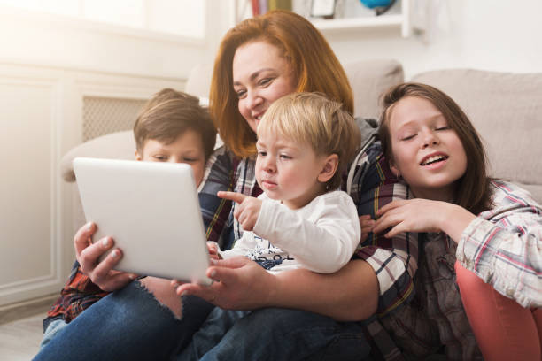 istock Happy mother with children using tablet together 962234624