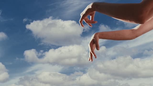The dancing female hands at sky background