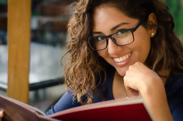istock A smiling woman in a restaurant with the menu in hands 962247176
