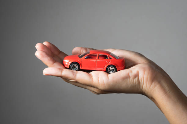 istock Red toy car in girl hand. 962256444