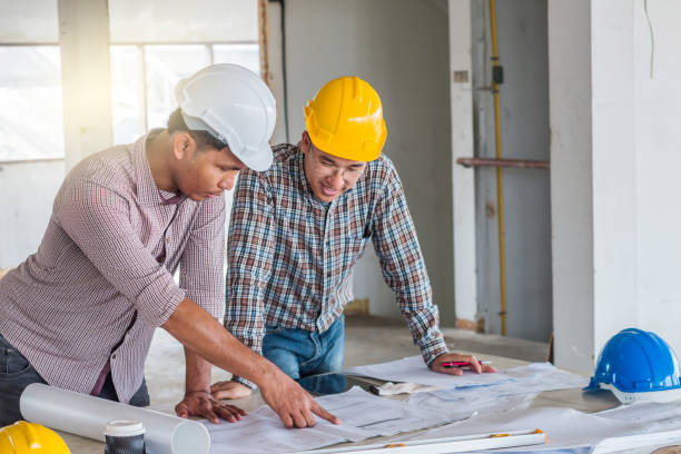 istock Group of engineer checking the blueprint on the table and talking about construction project with commitment to success at construction site 962256766