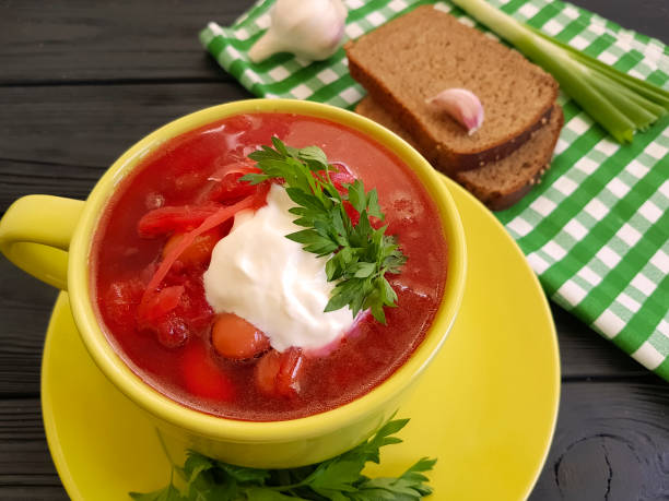 istock red soup, bread, garlic on a black wooden background 962257360
