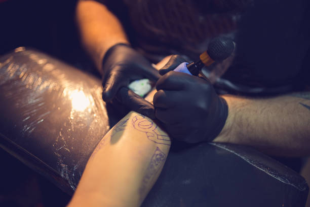 istock Artist making tattoo on man's hand 962264164