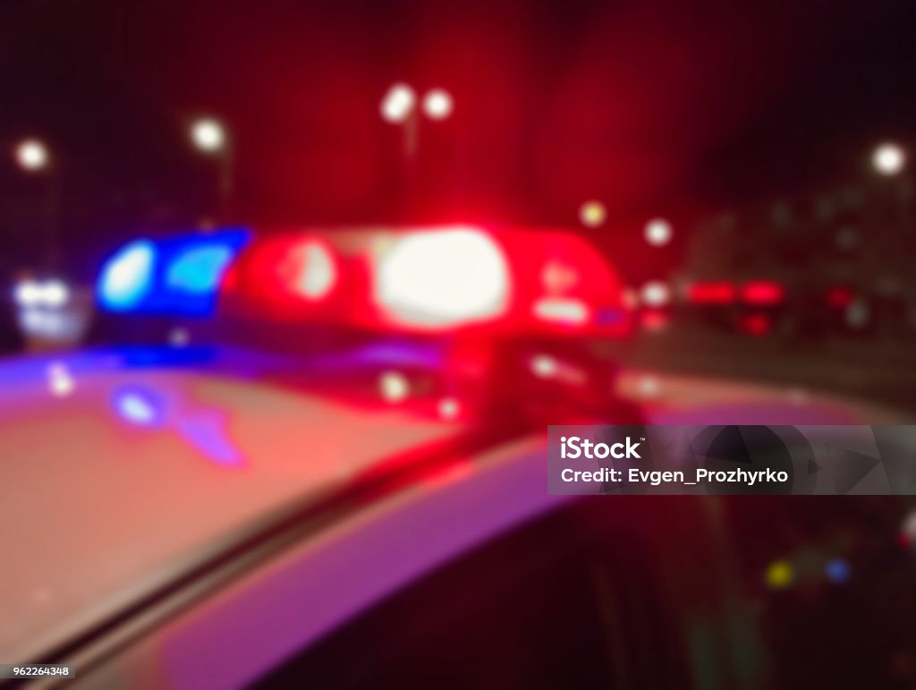 Red and blue lights of police car in night time, crime scene. Night patrolling the city. Abstract blurry image. Police Vehicle Lighting Stock Photo