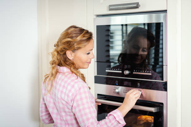 istock woman turning on the oven in the kitchen 962264356