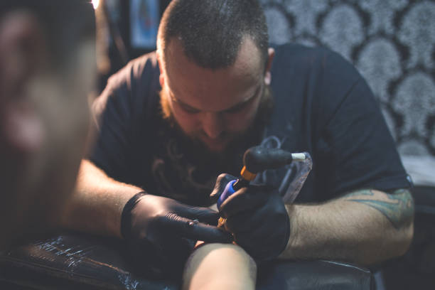 istock Tattooist tattooing young mans arm 962266798