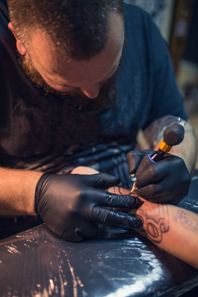 istock Artist making tattoo on man's hand in studio 962267046