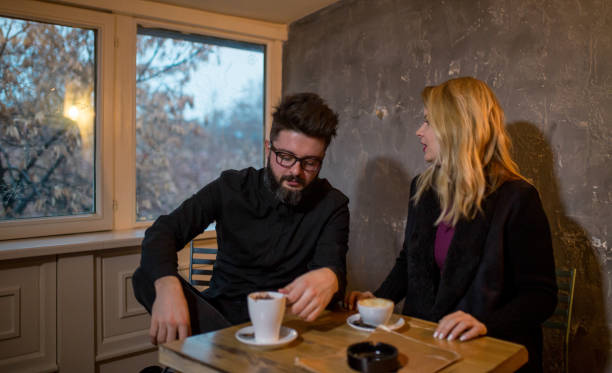 istock Happy young couple is drinking coffee and smiling while sitting at the cafe 962270794