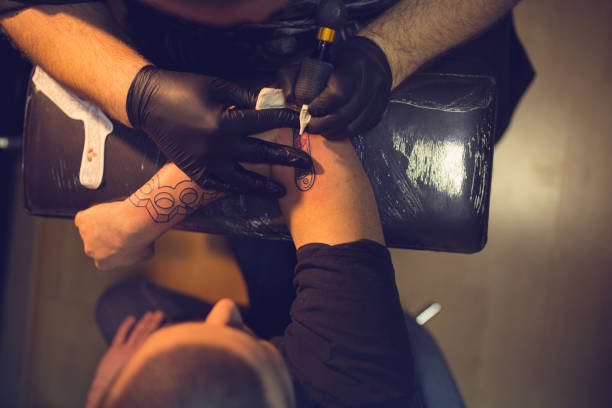 istock Man getting a new tattoo on his arm. 962271218