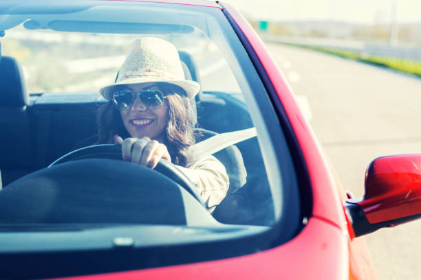 istock Happy woman driving a convertible car 962271358