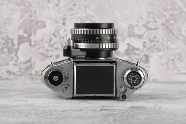 istock The old 35 mm film camera on a grey cement background. 962271392
