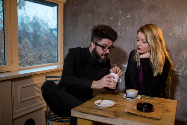 istock Happy young couple is drinking coffee and smiling while sitting at the cafe 962271600