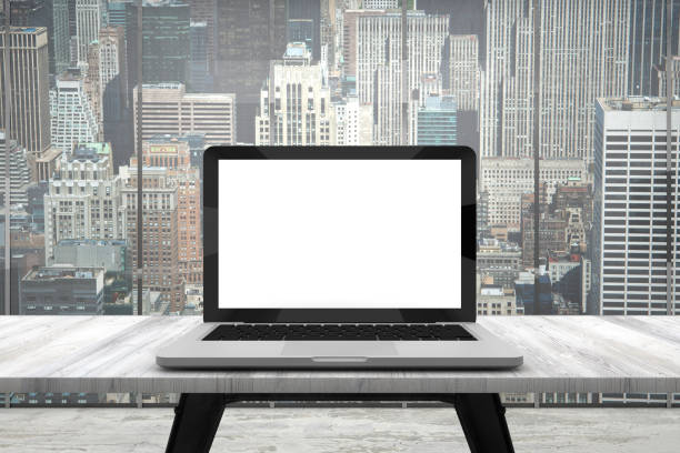 istock Laptop with blank screen on wood table in office 962279162