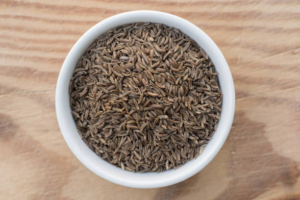 carum seeds in small bowl carum seeds in small bowl om wooden table carum carvi stock pictures, royalty-free photos & images