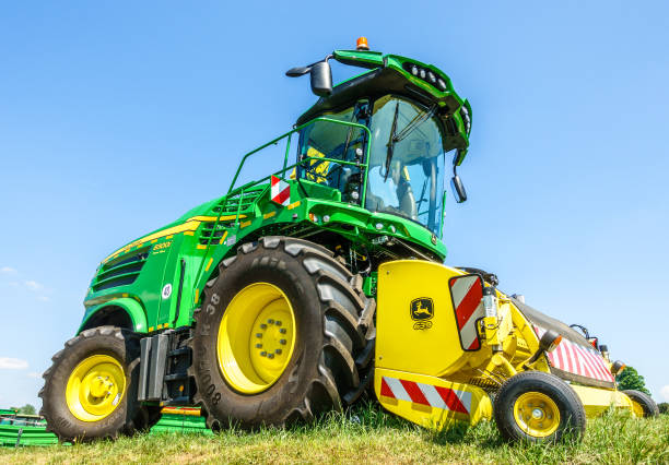 john deere tractor - non urban scene landscaped clear sky germany fotografías e imágenes de stock