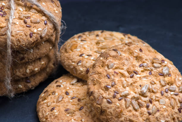 istock Savory cookies sprinkled with sesame seeds, sunflower on shale board 962305866