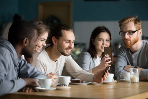 istock Multi-ethnic group of friends talking and using smartphones at meeting 962315284