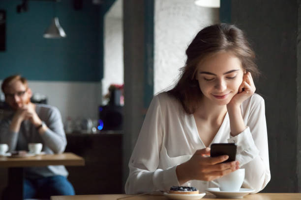 jeune mec belle dame dans le café en regardant avec intérêt - regarder fixement photos et images de collection