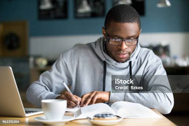 Fokussierte Tausendjährigen Afrikanische Student Notizen Während Des Studiums In Café Stockfoto und mehr Bilder von Akademisches Lernen