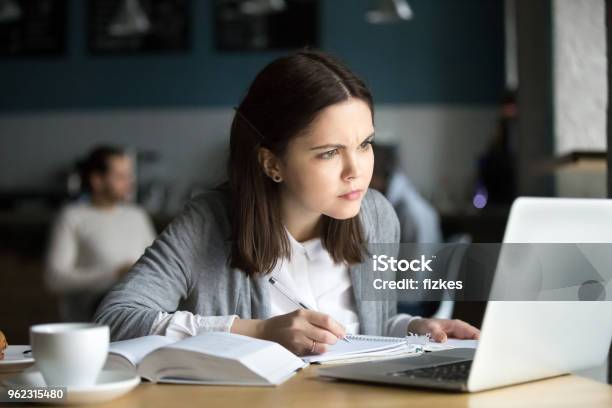 Focused Girl Concerned About Difficult Online Task Studying In Cafe Stock Photo - Download Image Now