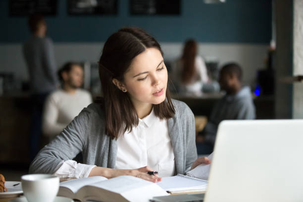 istock Serious intelligent millennial girl studying in cafe preparing for exam 962315512