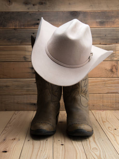 Cowboy boot and western hat on wooden background.
