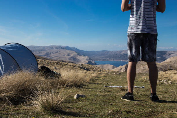 istock Man standing next to a tent and looking at amazing view 962322298