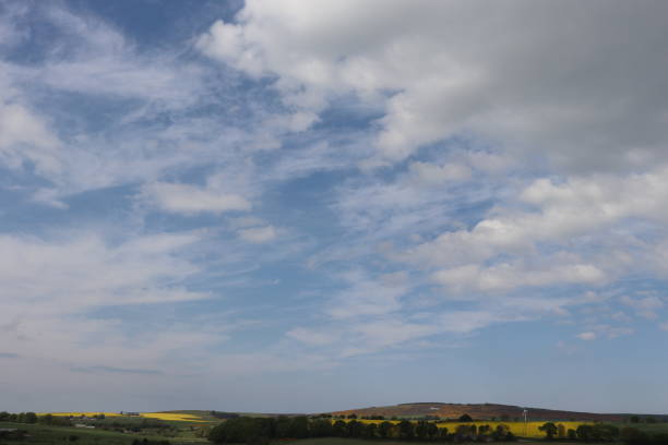istock Fluffy white clouds in blue sky over fields in countryside 962322462