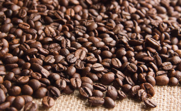 istock fried coffee beans are scattered on beige burlap cloth 962329374