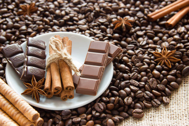 istock fried coffee beans with a bunch of cinnamon sticks with milk and black chocolate and biscuits on the sacking 962329502