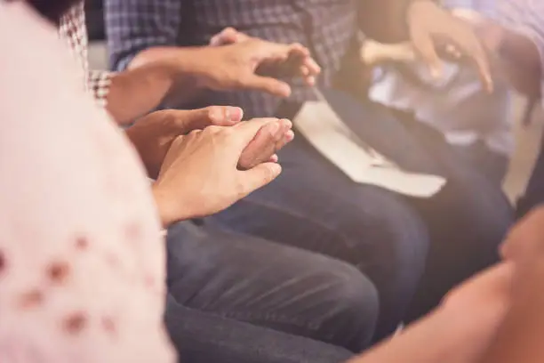 Photo of Christians  and Bible study concept. Group of discipleship Studying the Word Of God in church and Christians holding each others hand praying together