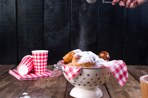 traditional oliebollen, oil dumpling or fritter, with wooden spoon, for Dutch New Year's Eve