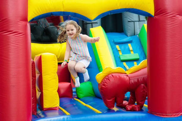 istock Child jumping on playground trampoline. Kids jump. 962343782