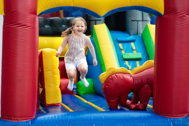 istock Child jumping on playground trampoline. Kids jump. 962344616