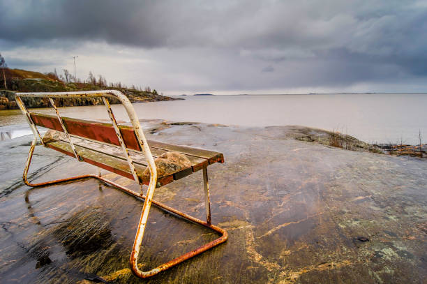 istock Rusty bench by the sea in Helsinki, Finland, on a spring cloudy day 962351430