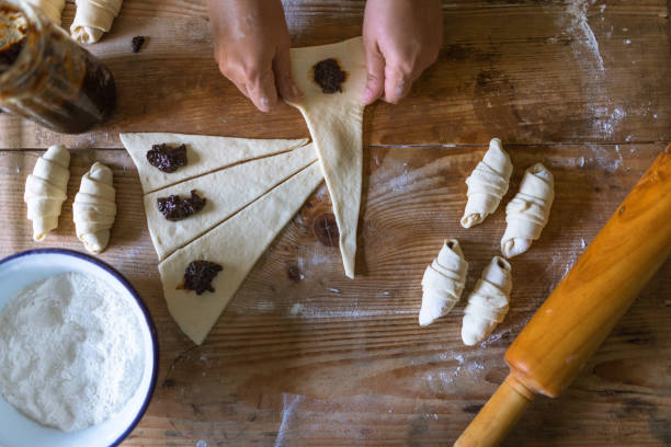 istock Housewife roll pieces of dough with plum jam 962353686