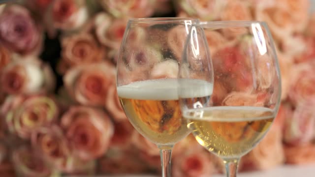 Two glasses of sparkling wine and large bouquet of pink roses