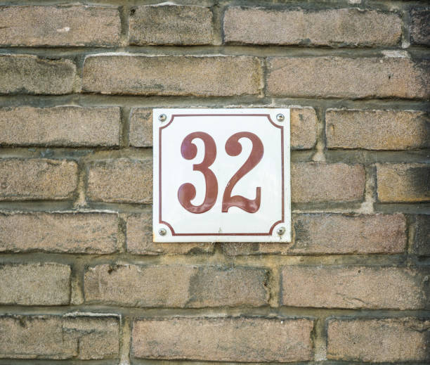 istock House Number 32 thirty two. brown numbers on a white plate constructed to a old brick wall 962357802
