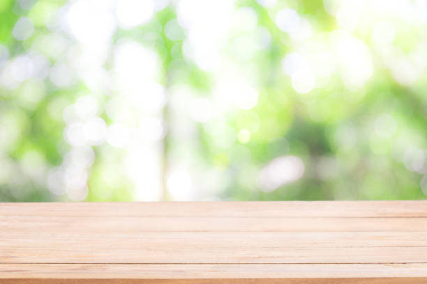 istock Empty wooden table with Defocus nature green bokeh, abstract nature background. 962358732