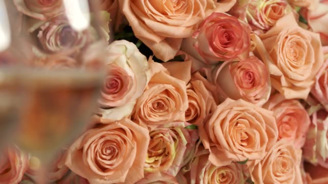 Dolly: Two glasses of sparkling wine and large bouquet of pink roses