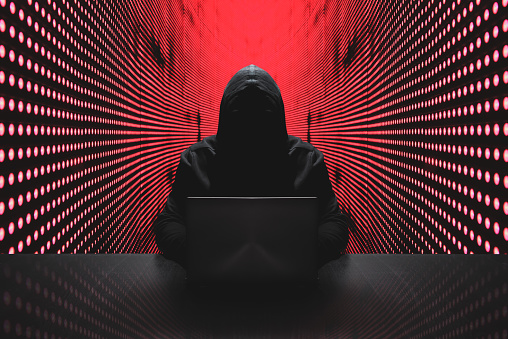 Anonymous hacker con el portátil delante de ciberseguridad de código binario photo