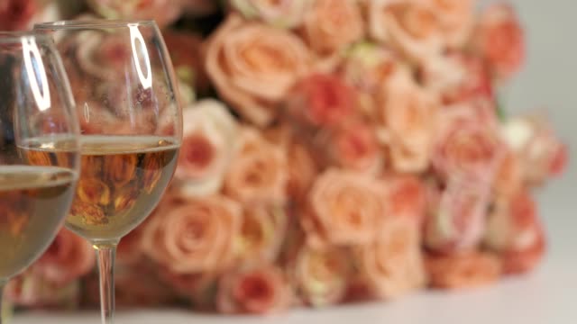 Dolly: Two glasses of sparkling wine and large bouquet of pink roses