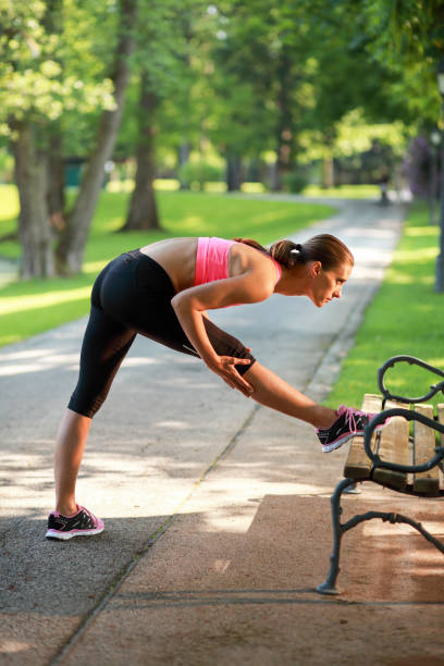 istock Female jogger stretching on a park bench 962378148