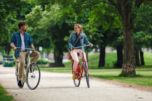 istock Happy Young Couple Riding Bicycles In Park 962379254
