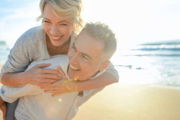 istock Mature couple playing on the beach at sunset or sunrise. 962382690