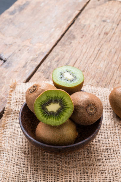 istock Kiwi fruit in a bowl on wooden background. 962387666
