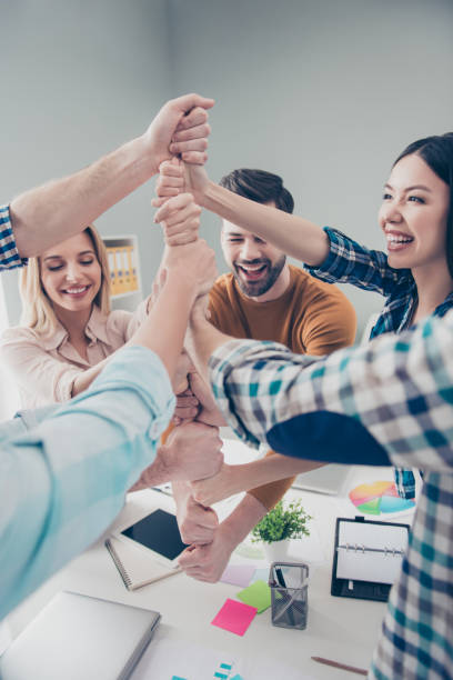 istock Agreement, achievement, harmony, progress, motivation, inspiration, power concept. Cropped portrait of cheerful, joyful, positive business people putting fists on top of each other in workplace 962396602
